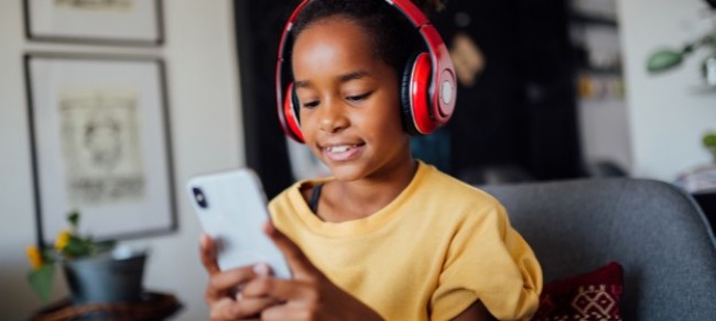A child with headphones and a phone
